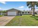 Single Gathering home features a well-maintained lawn and inviting curb appeal at 2175 Edythe Dr, Dunedin, FL 34698