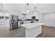 Bright kitchen featuring modern white cabinets, a marble island, stainless steel appliances, and geometric backsplash at 2175 Edythe Dr, Dunedin, FL 34698