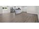 Open concept kitchen featuring hardwood floors, white cabinetry, a marble island, and stainless steel appliances at 2175 Edythe Dr, Dunedin, FL 34698