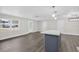 Open concept living area featuring wood floors, white walls, multiple doors, and a large kitchen island at 2175 Edythe Dr, Dunedin, FL 34698