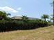 Outdoor screened-in patio, surrounded by lush hedges, providing shade and privacy at 25352 Doredo Dr, Punta Gorda, FL 33955
