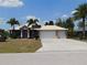 Charming single-story home with double-door entrance, three-car garage, and well-maintained lawn at 25352 Doredo Dr, Punta Gorda, FL 33955