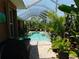 Relaxing pool area with a screened enclosure, tropical plants, and clear water at 25352 Doredo Dr, Punta Gorda, FL 33955