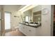 Well-lit bathroom with double sinks, large mirrors, and a separate toilet and shower area at 3102 Lema Dr, Spring Hill, FL 34609