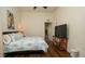 Comfortable bedroom with hardwood floors, a queen bed, and a modern TV stand at 3102 Lema Dr, Spring Hill, FL 34609