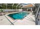 A well-maintained backyard pool is surrounded by a patio and white privacy fence at 3102 Lema Dr, Spring Hill, FL 34609