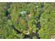 Secluded property featuring a house nestled among lush trees near a winding creek at 3431 Riderwood Dr, Dade City, FL 33523