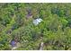 Aerial view showcases a house nestled amongst lush green trees, emphasizing seclusion and natural beauty at 3431 Riderwood Dr, Dade City, FL 33523