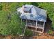 Aerial view of a home featuring a screened porch and a metal roof surrounded by lush greenery and trees at 3431 Riderwood Dr, Dade City, FL 33523