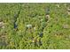 Aerial view of a secluded house surrounded by lush greenery and a beautiful winding creek at 3431 Riderwood Dr, Dade City, FL 33523