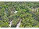Stunning aerial view of a home nestled among lush trees, showcasing privacy and natural beauty at 3431 Riderwood Dr, Dade City, FL 33523