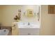Charming bathroom with a vanity featuring a white countertop, oval mirror, and decorative floral accents at 3431 Riderwood Dr, Dade City, FL 33523