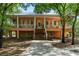 Two-story home with a large, inviting wraparound porch and mature trees in a serene setting at 3431 Riderwood Dr, Dade City, FL 33523