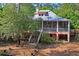 View of home with porch featuring stairs to the deck and yard surrounded by lush greenery and trees at 3431 Riderwood Dr, Dade City, FL 33523