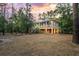 Expansive backyard at dusk showcasing the charming two-story home with a large screened porch at 3431 Riderwood Dr, Dade City, FL 33523