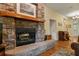 Stone fireplace with wood mantle, a cozy focal point, complemented by hardwood flooring at 3431 Riderwood Dr, Dade City, FL 33523