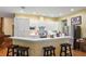 Modern kitchen features white cabinets, stainless appliances, stone backsplash, and breakfast bar with bar stool seating at 3431 Riderwood Dr, Dade City, FL 33523