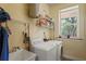 Well-lit laundry room with modern washer and dryer units, window, and shelving at 3431 Riderwood Dr, Dade City, FL 33523