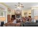 Bright living room features a stone fireplace, ceiling fan, and hardwood floors, perfect for relaxing and entertaining at 3431 Riderwood Dr, Dade City, FL 33523