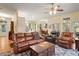 Open living space with comfortable leather furniture, hardwood floors, and a view of the kitchen at 3431 Riderwood Dr, Dade City, FL 33523