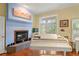 Main bedroom with fireplace, piano, hardwood floors, and balcony access at 3431 Riderwood Dr, Dade City, FL 33523