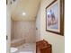 Modern, tiled shower with built-in bench and ample space, adjacent to a wooden laundry hamper at 3431 Riderwood Dr, Dade City, FL 33523