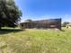 Lovely backyard featuring a screened-in pool, a large lawn, and mature trees, perfect for outdoor enjoyment at 3464 Misty View Dr, Spring Hill, FL 34609