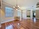 The dining room boasts hardwood floors, decorative trim, chandelier lighting, and large window at 3464 Misty View Dr, Spring Hill, FL 34609