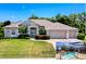 Beautiful single-story home with a three-car garage, lush landscaping, and a screened-in pool area at 3464 Misty View Dr, Spring Hill, FL 34609