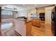 Open-concept kitchen with wood floors, island, and access to living area at 3464 Misty View Dr, Spring Hill, FL 34609