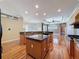 Open kitchen with wood floors, island, granite countertops, and modern appliances at 3464 Misty View Dr, Spring Hill, FL 34609