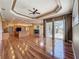 Spacious living room with wood floors, tray ceiling, recessed lighting, fireplace and kitchen in background at 3464 Misty View Dr, Spring Hill, FL 34609