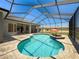 Inviting pool with screened enclosure, brick patio, and outdoor umbrella at 3464 Misty View Dr, Spring Hill, FL 34609