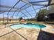 Refreshing pool with screened enclosure, umbrella and brick patio at 3464 Misty View Dr, Spring Hill, FL 34609