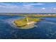 Stunning aerial view of a private island with lush greenery surrounded by turquoise waters at 4934 Amherst Ct, New Port Richey, FL 34652