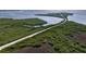 Aerial view of a scenic road winding through lush greenery and water, offering a unique coastal perspective at 4934 Amherst Ct, New Port Richey, FL 34652