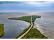 An aerial view of a scenic roadway leading to a lush, green island surrounded by tranquil water at 4934 Amherst Ct, New Port Richey, FL 34652