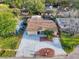 Aerial view of a well-maintained home with a long driveway, mature trees, and a manicured lawn at 4934 Amherst Ct, New Port Richey, FL 34652