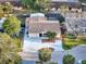 Aerial view of a home with a well-kept lawn, mature trees, and a long driveway in a quiet neighborhood at 4934 Amherst Ct, New Port Richey, FL 34652