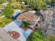A beautiful aerial view of a home with lush landscaping, a long driveway, and mature trees at 4934 Amherst Ct, New Port Richey, FL 34652
