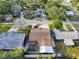 Aerial view of a home with a pool, covered patio, lush landscaping, and a well-maintained roof at 4934 Amherst Ct, New Port Richey, FL 34652