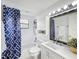 Bathroom with white cabinets, a framed mirror, and blue and white patterned shower curtain at 4934 Amherst Ct, New Port Richey, FL 34652
