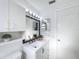 Bright bathroom features white cabinets, a framed mirror with vanity lights, and a neutral color scheme at 4934 Amherst Ct, New Port Richey, FL 34652