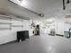 A well-lit garage with a gray epoxy floor, laundry area, utility connections, and storage at 4934 Amherst Ct, New Port Richey, FL 34652