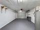 A spacious garage featuring painted walls, a gray epoxy floor, shelves, and utility equipment at 4934 Amherst Ct, New Port Richey, FL 34652