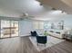 Bright living room with light blue walls, modern furniture, and sliding glass doors to the outdoor patio at 4934 Amherst Ct, New Port Richey, FL 34652