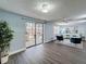 Bright living room with light blue walls, ceiling fan, and sliding glass doors to the outdoor patio at 4934 Amherst Ct, New Port Richey, FL 34652