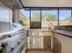 A stainless steel outdoor kitchen with built-in grill, sink and bar area at 4934 Amherst Ct, New Port Richey, FL 34652