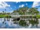 Picturesque pond view featuring a charming gazebo, lush greenery, and tranquil reflections on the water at 4934 Amherst Ct, New Port Richey, FL 34652