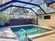 Well-lit private pool in a screened enclosure, surrounded by lush landscaping at 4934 Amherst Ct, New Port Richey, FL 34652